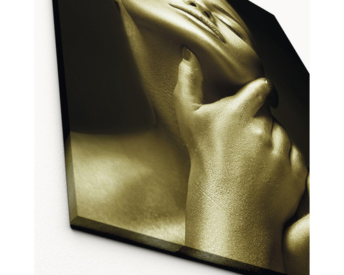 Prim-plan al unei imprimări de artă de culoarea aurului, care arată o femeie cu mâna atingându-i fața