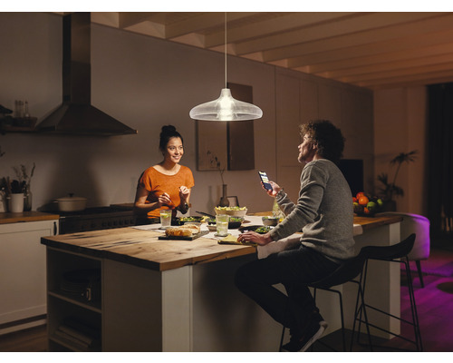 Lampa suspendată deasupra mesei de sufragerie într-o bucătărie modernă cu două persoane