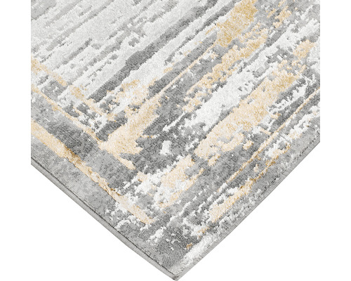 Prim-plan cu un covor cu model abstract în gri și crem.