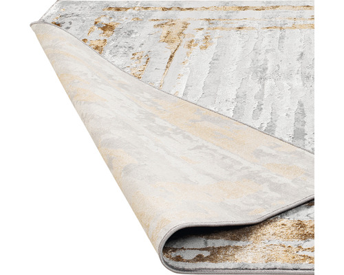 Covor cu model abstract, parțial rulat pentru a arăta partea din spate.