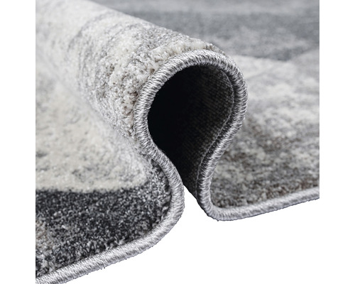 Vizualizare detaliată a unui covor gri cu model amestecat și margine legată.