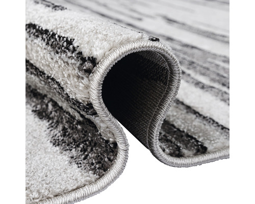 Vizualizare detaliată a unui covor cu model abstract și margini festonate