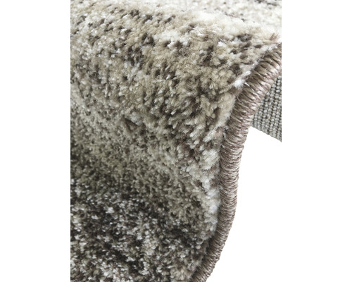 Prim-plan cu un covor cu model amestecat și margini finisate.