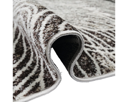 Detaliu al unui covor cu model cu margine rulată