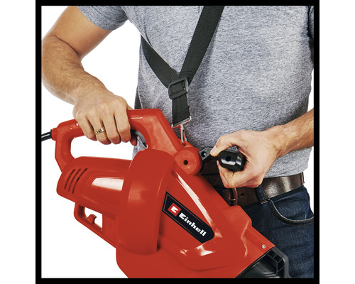 O persoană operează un aspirator de frunze cu curea de transport.