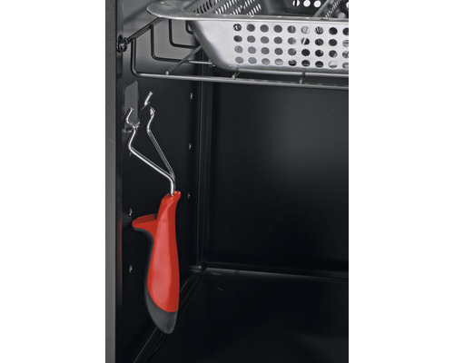 Interiorul unui grătar cu clește de grătar și tavă de colectare