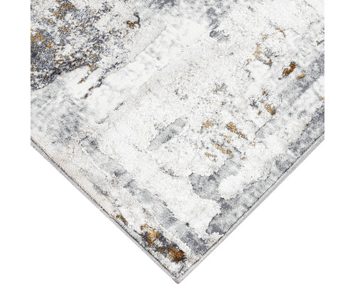 Imagine detaliată a unui covor cu model abstract în tonuri de gri, alb și auriu.