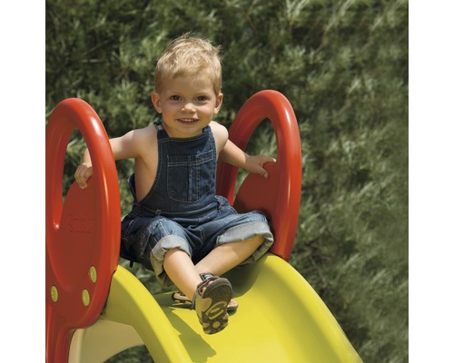 Copil pe un tobogan în grădină