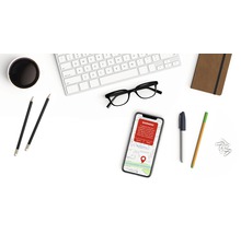 Tastatură, ochelari, smartphone cu mesaj de avertizare, blocnotes și pixuri pe un birou