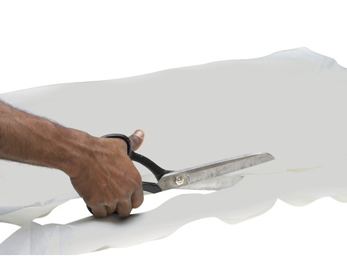 O mână taie o țesătură cu o foarfecă.