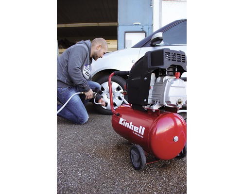 Bărbat umflă o anvelopă de mașină cu un compresor Einhell