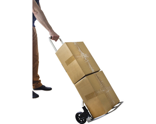 O persoană transportă două cutii de carton cu un cărucior.