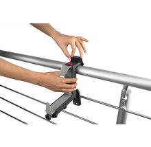 Persoană care atașează suportul uscătorului de rufe de o balustradă