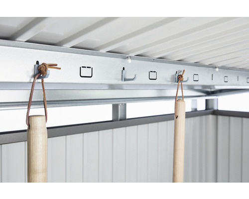 Imagine detaliată a interiorului unei magazii de grădină cu o bandă cu cârlige pentru agățarea uneltelor