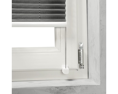 Prim-plan cu o fereastră cu jaluzea plisată gri și elemente de operare