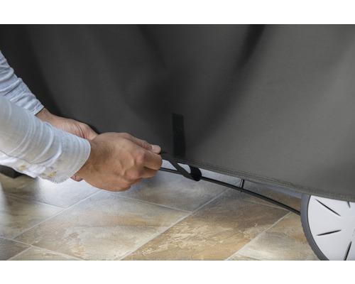 Persoană care fixează o husă de grătar cu închidere cu velcro