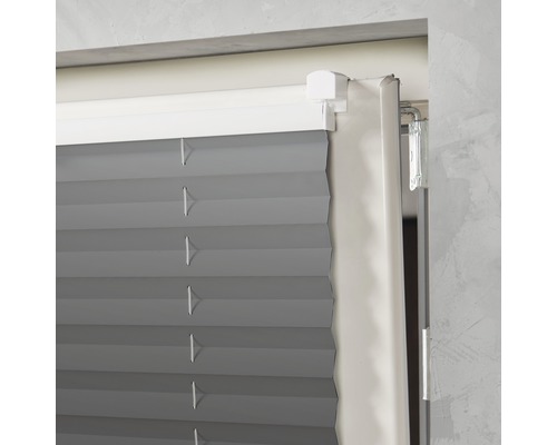 Imagine detaliată cu un jaluzele plisate gri la fereastră.