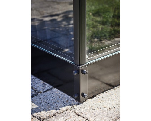 Detaliu al unei construcții de sticlă cu conexiune metalică de colț și înșurubare.