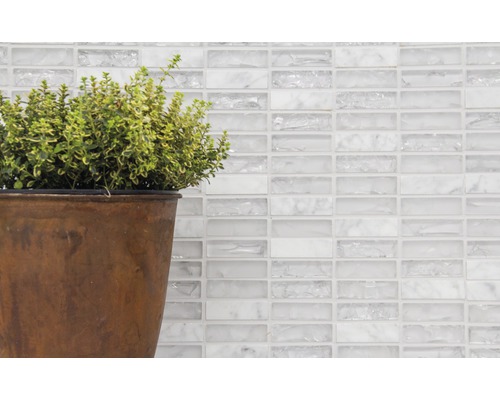 Perete decorativ cu plăci de mozaic din sticlă albă și plantă la ghiveci