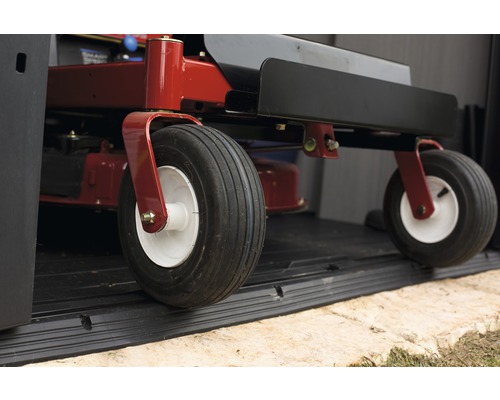 Prim-plan cu o mașină de tuns iarba cu anvelope într-o magazie de grădină