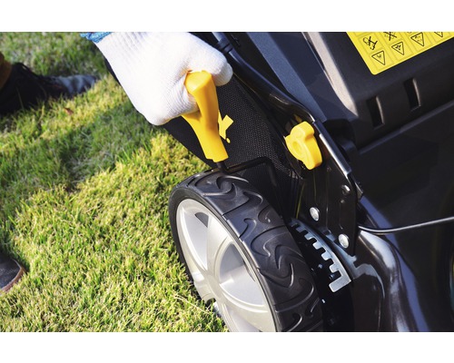 Prim-plan cu o mașină de tuns iarba cu o persoană care ține de mâner