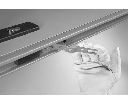 O persoană cu mănușă folosește o tijă de montaj pe o cutie de distribuție.