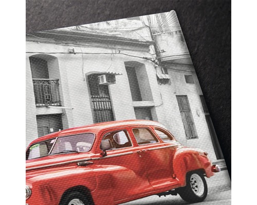 Prim-plan al unei pânze imprimate cu o mașină de epocă roșie în fața unei clădiri