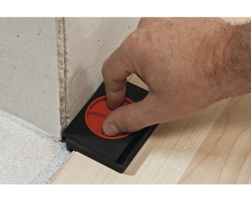 Persoană care utilizează un instrument de reglare pentru panouri pe perete