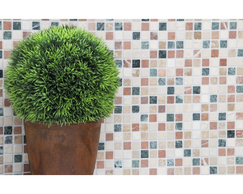 Plantă artificială în ghiveci în fața unui fundal de mozaic