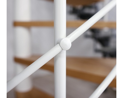 Prim-plan al unei balustrade albe de scară cu trepte din lemn în fundal
