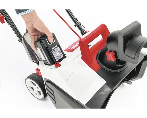 O mână introduce o baterie într-o freză de zăpadă cu acumulator