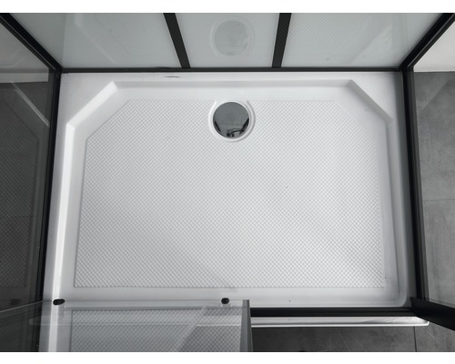 Cădiță de duș albă cu scurgere într-o cabină de duș