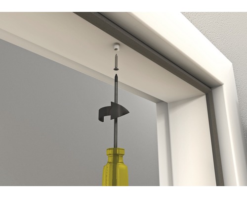 Montarea unei amortizoare de ușă cu o șurubelniță pe cadrul ușii