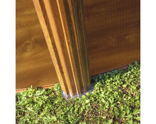 Detaliu al unei construcții de căsuță de grădină cu stâlpi și elemente de perete în aer liber.