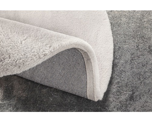 Vizualizare detaliată a unui covor de culoare deschisă cu suport textil