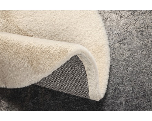 Prim-plan cu un covor bej cu fibre lungi și suport textil