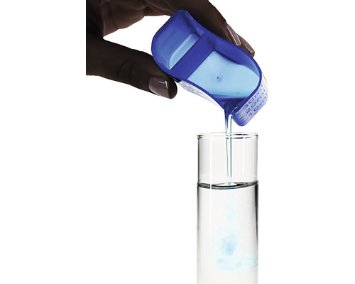 Un lichid este turnat într-o eprubetă folosind o cană de măsurare albastră.