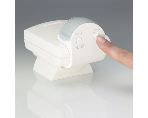 Senzor de mișcare cu butoane de reglare și un deget care apasă un buton