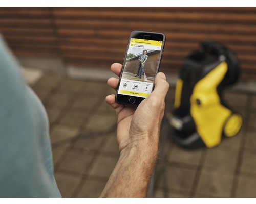 O persoană folosește o aplicație de smartphone pentru curățarea cu înaltă presiune