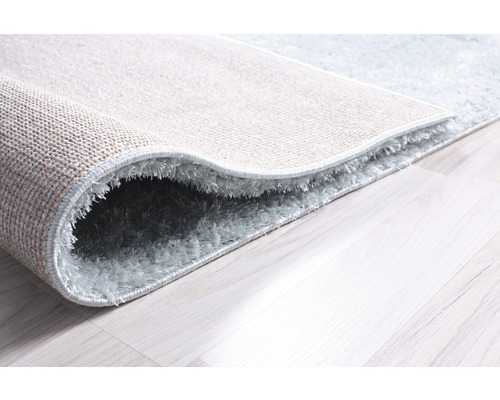 Prim-plan al unui covor shaggy pe o podea de lemn