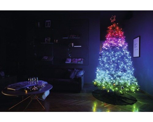 Brad de Crăciun cu lumini în camera de zi, lângă o masă cu decorațiuni