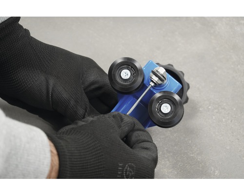 Utilizatorul ajustează unealta pe role cu o cheie hexagonală