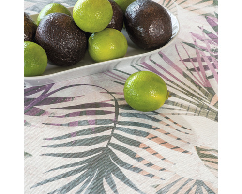 Avocado și lime pe o farfurie pe o față de masă cu model de frunze.