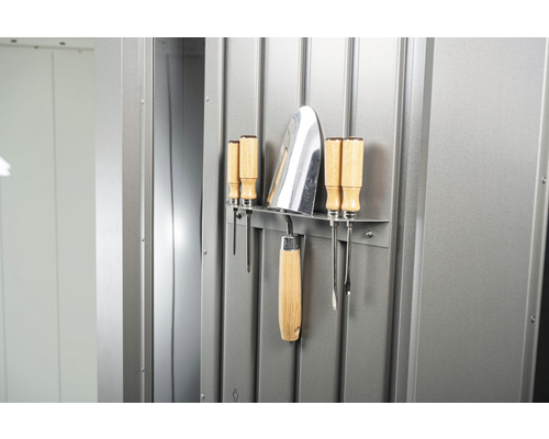 Unelte de grădinărit agățate pe un perete metalic