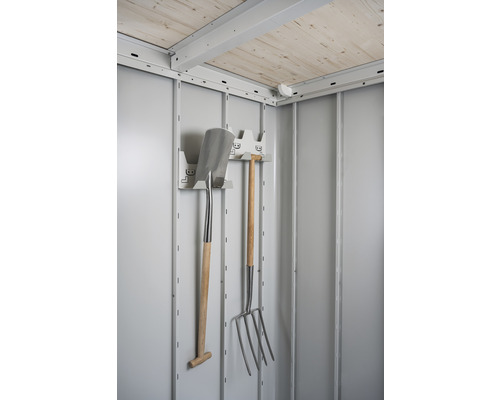 Interiorul unei magazii de grădină cu lopată, furcă și suport pentru unelte