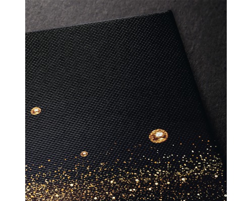 Prim-plan cu o imagine pe pânză neagră, cu accente de sclipici auriu