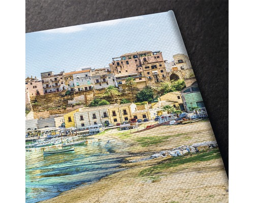 Prim-plan al unei pânze cu o imagine a unui oraș de coastă