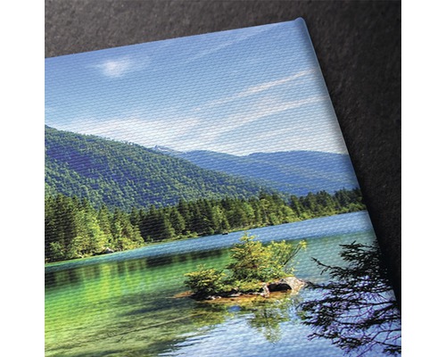 Prim-plan al unei pânze cu motivul unui lac de munte și dealuri împădurite