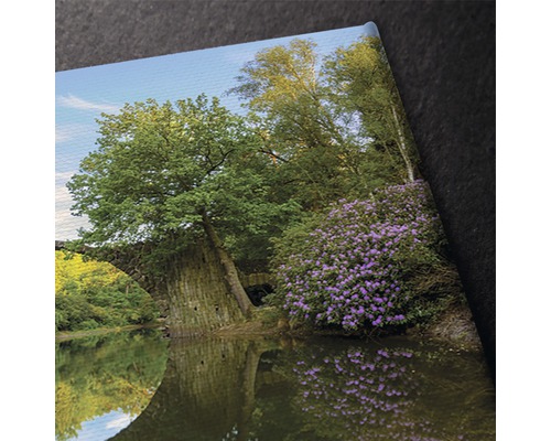 Imagine decorativă a unui pod de piatră peste un lac cu copaci