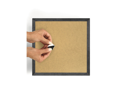 Persoană care fixează un suport autoadeziv pe spatele unei rame foto.